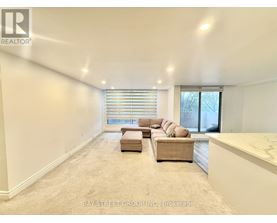 A spacious living room with a large window and a sectional sofa.