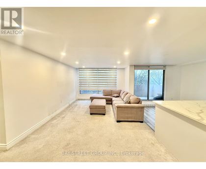 A spacious living room with a large window and a sectional sofa.