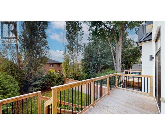 A deck with a railing and a view of a backyard with a pool.