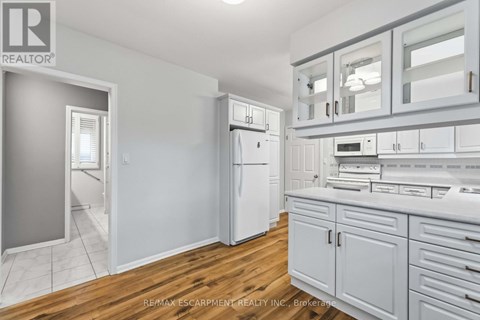 A kitchen with white appliances and cabinets.