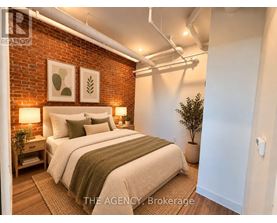 A bedroom with a brick wall and a bed with a green throw.
