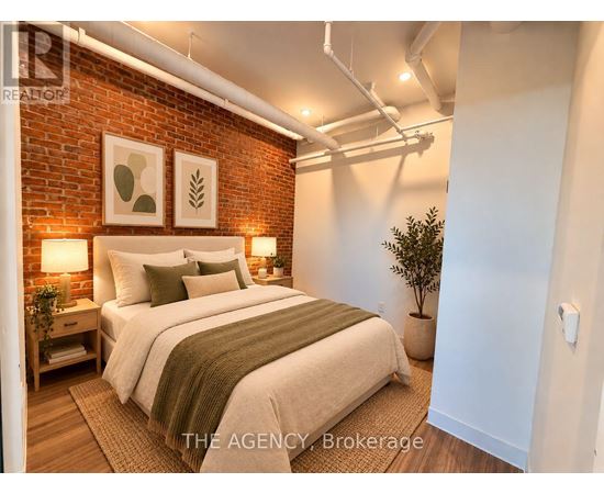 A bedroom with a brick wall and a bed with a green throw.