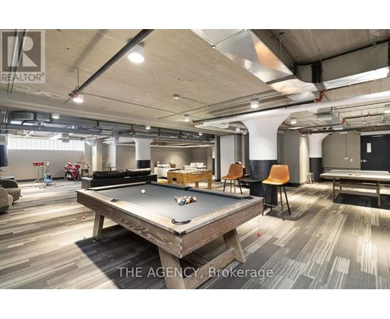 A billiard table is in the middle of a room with a pool table and a ping pong table.