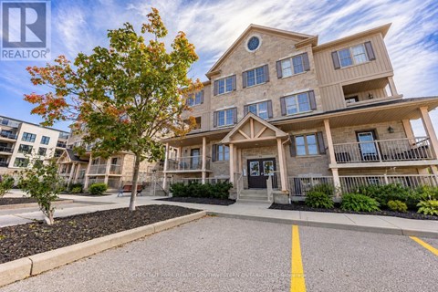 A large apartment complex with a tree in front of it.