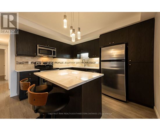 A modern kitchen with a stainless steel refrigerator and a center island.
