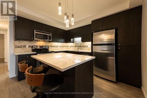 A modern kitchen with a stainless steel refrigerator and a center island.