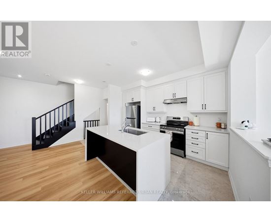 A modern kitchen with white cabinets and a black countertop.