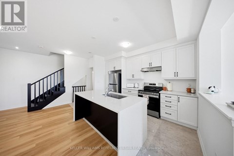 A modern kitchen with white cabinets and a black countertop.
