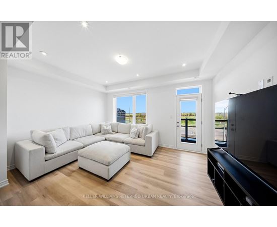 A spacious living room with a white sofa set and a black television.