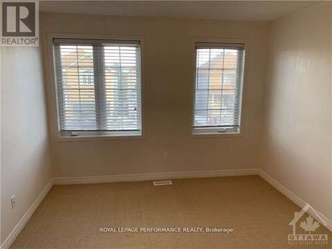 A room with two windows and a carpeted floor.
