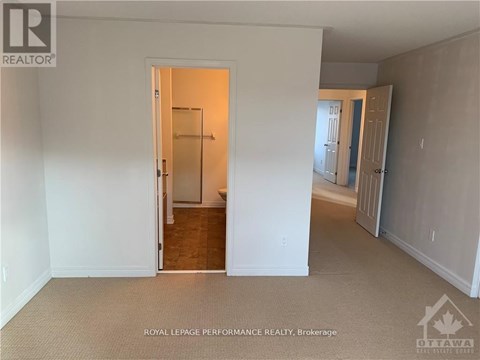 A white room with a doorway leading to another room.