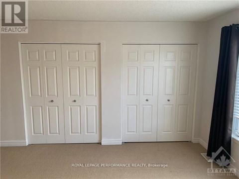 A room with two white doors and a carpet floor.