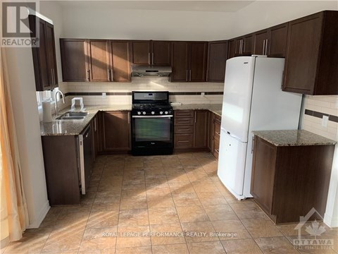 A kitchen with brown cabinets and a white refrigerator.