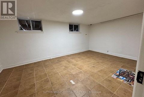 A room with tiled flooring and two windows.