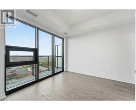 A spacious room with large windows and a view of the city.