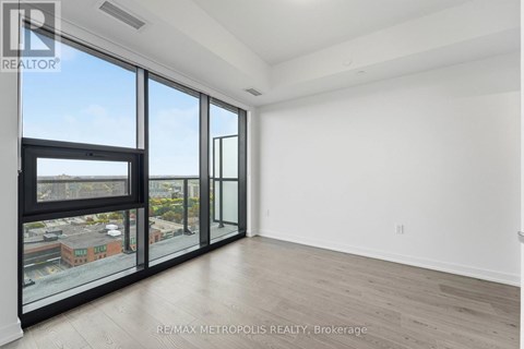 A spacious room with large windows and a view of the city.