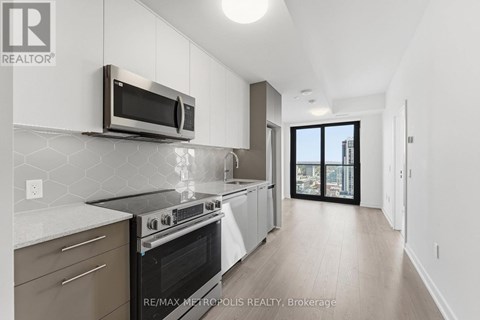 A modern kitchen with a stainless steel microwave above the stove.