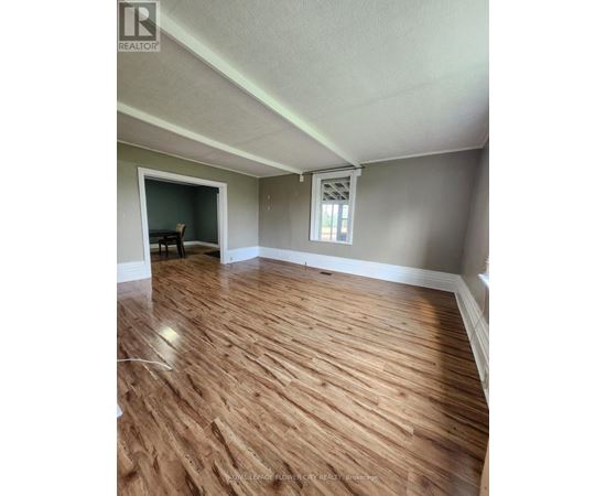 A room with wooden flooring and a window.