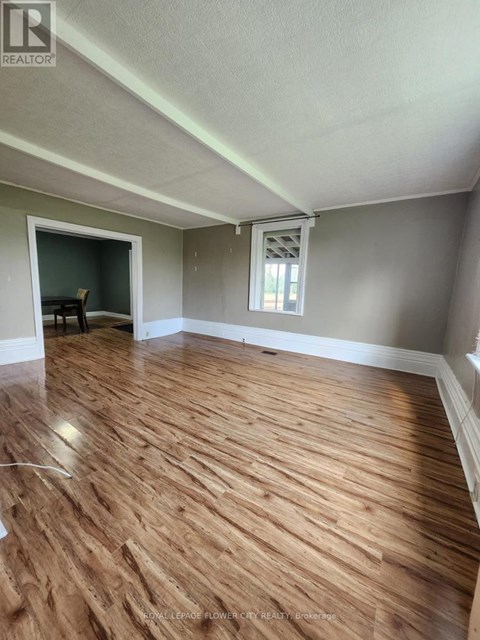 A room with wooden flooring and a window.