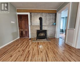A wood stove is in a room with hardwood floors.