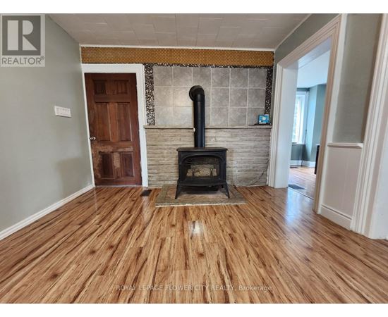 A wood stove is in a room with hardwood floors.