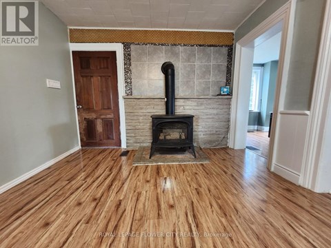 A wood stove is in a room with hardwood floors.