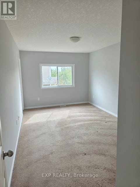 A room with a carpeted floor and a window.