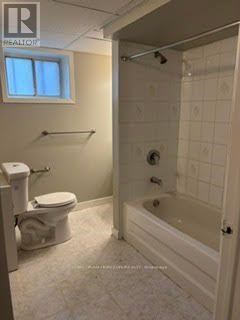 A white bathroom with a toilet, sink, and bathtub.