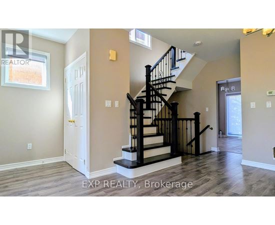 A spacious room with a staircase leading to the upper level.