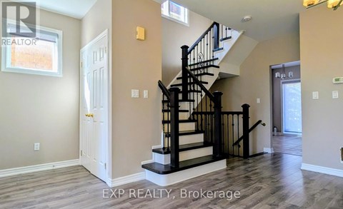 A spacious room with a staircase leading to the upper level.
