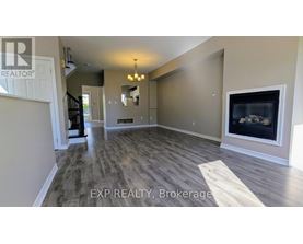 A spacious living room with wood flooring and a fireplace.