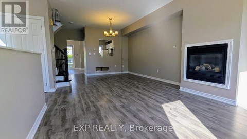 A spacious living room with wood flooring and a fireplace.