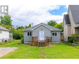 A small house with a white door and a wooden fence in front of it.