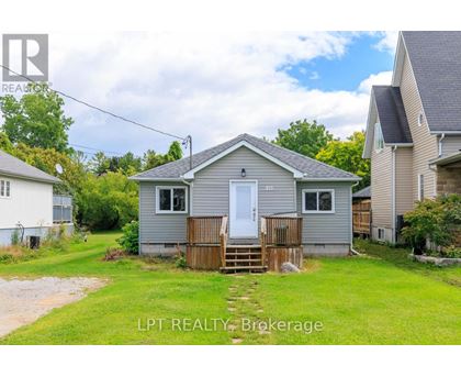 A small house with a white door and a wooden fence in front of it.