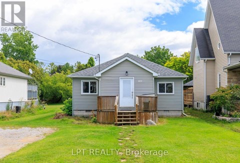 A small house with a white door and a wooden fence in front of it.