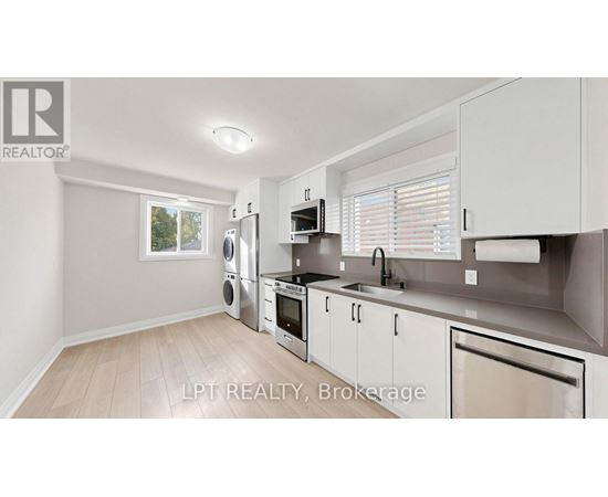 A modern kitchen with white cabinets and stainless steel appliances.