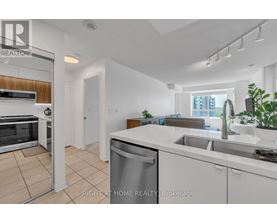 A modern kitchen with white cabinets and stainless steel appliances.