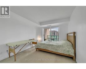 A bedroom with a bed, desk, and chair.