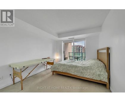 A bedroom with a bed, desk, and chair.