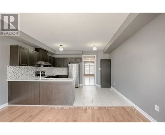 A modern kitchen with a wooden floor and a large island.