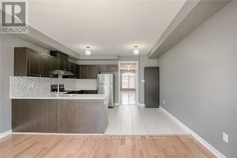 A modern kitchen with a wooden floor and a large island.