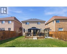 A real estate photo of a house with a gazebo in the yard.