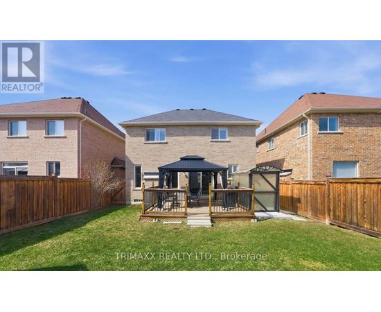 A real estate photo of a house with a gazebo in the yard.