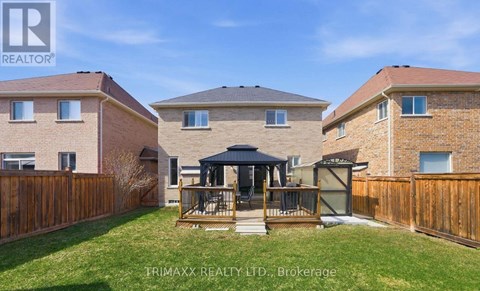 A real estate photo of a house with a gazebo in the yard.