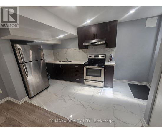 A kitchen with a stainless steel refrigerator and a stove top oven.