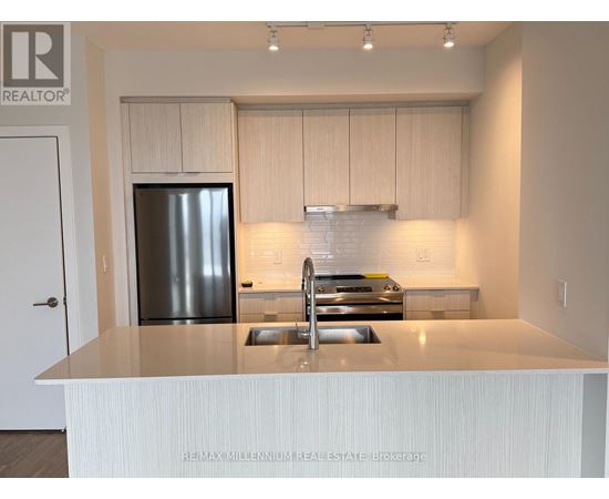 A kitchen with a stainless steel refrigerator and a white countertop.