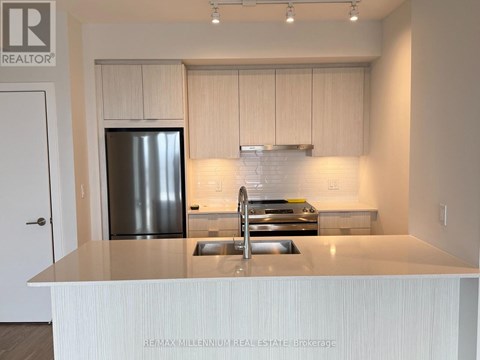 A kitchen with a stainless steel refrigerator and a white countertop.