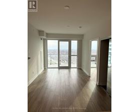 A spacious room with a view of the city through large windows.
