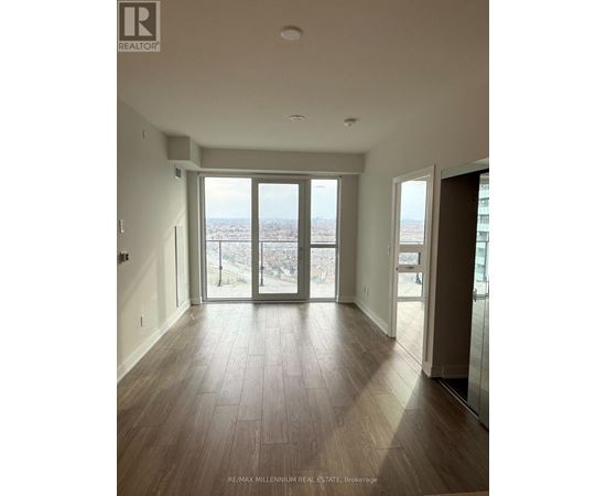 A spacious room with a view of the city through large windows.