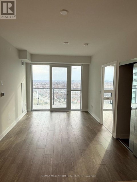 A spacious room with a view of the city through large windows.